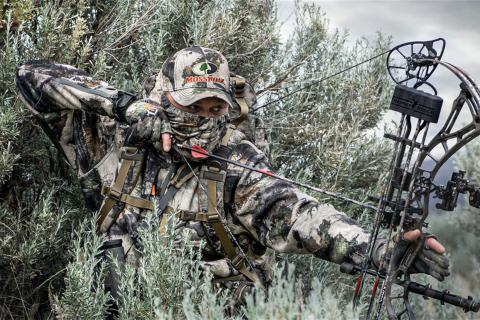 A bow hunter in camo clothing