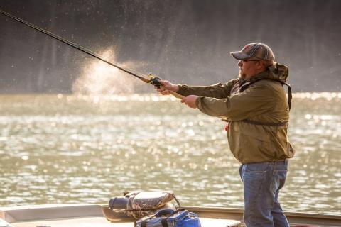 Angler fishing from a boat casting into the water