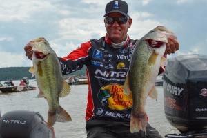 Kevin VanDam just after a fishing tournament holding up two of his largest bass